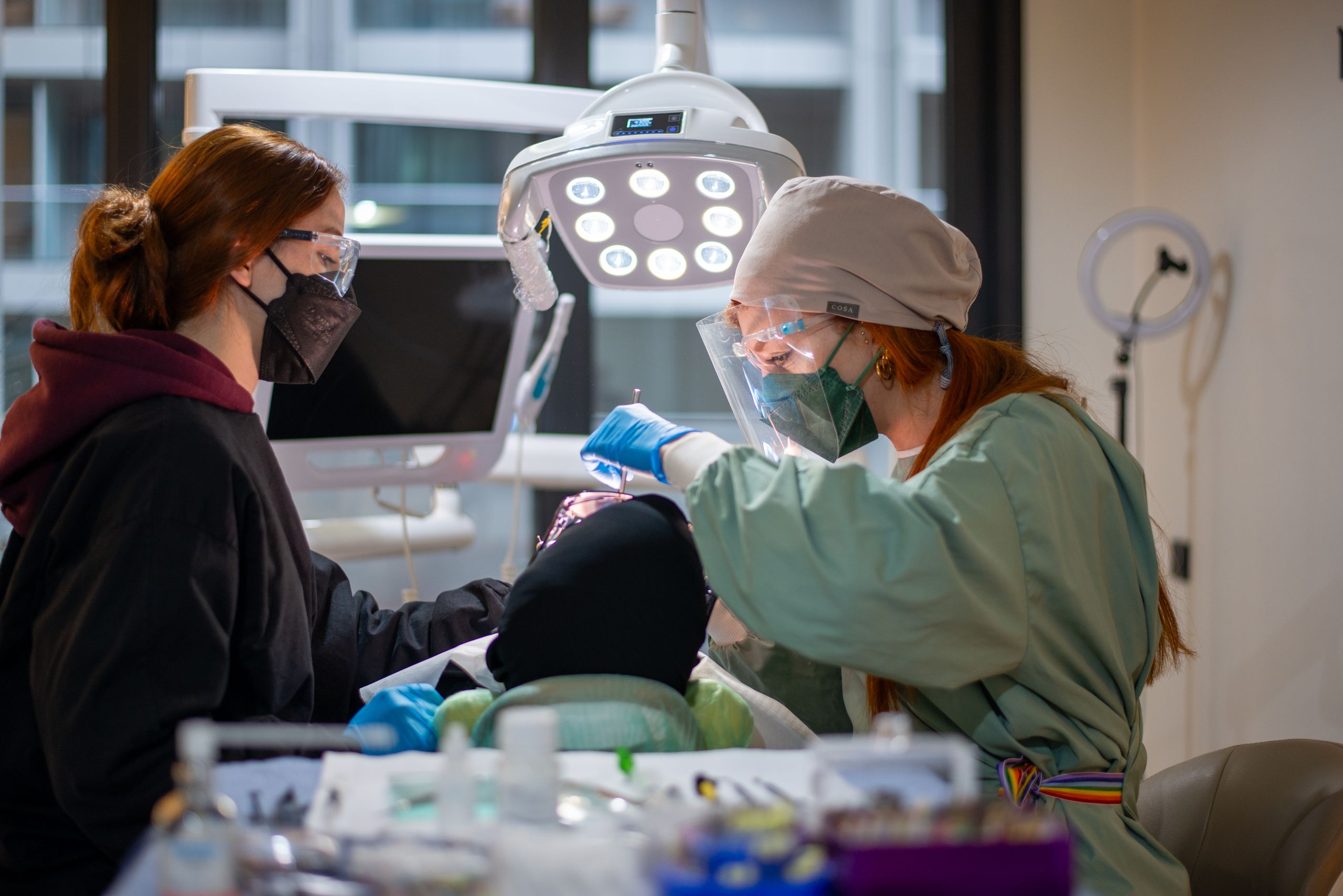 Dentist and assistant performing dental procedure in a well-equipped clinic.